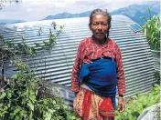  ??  ?? LEFT Sixty-year-old Miley Tamang, a corn farmer, stands proudly in front of her son’s solar cell-fitted temporary shelter.