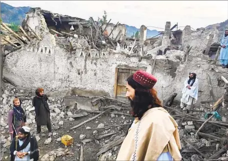  ?? Bakhtar News Agency ?? RESIDENTS in the remote Afghan region hit by the quake look over the devastatio­n. Most here in Paktika province have little equipment, and were left to search for victims by digging in the rubble with their bare hands, according to video from Bakhtar News Agency.