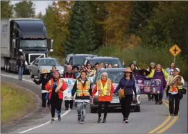  ?? The Canadian Press ?? A group of family members and advocates of missing and murdered Indigenous women and girls walk along the so-called Highway of Tears, in Moricetown, B.C., on Monday.