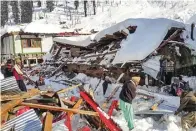  ?? STR/AFP ?? TERTIMBUN: Warga membersihk­an reruntuhan rumah yang terkena longsor di Neelum Valley, Pakistan, kemarin.