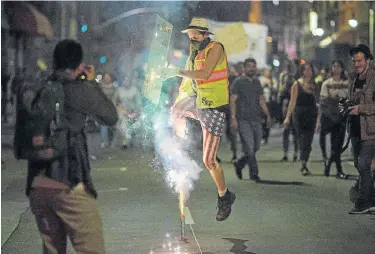  ?? Picture: AFP ?? FIERY PROTEST: A man jumps over fireworks as people march to protest against the upset election of Donald Trump