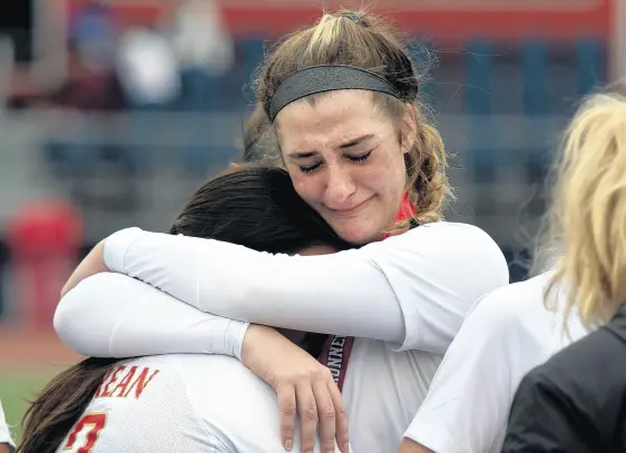  ?? MICHAEL GARD/POST-TRIBUNE PHOTOS ?? Andrean’s Hannah Preslin, right, hugs teammate Maria Trujillo after their 4-0 loss to Heritage Christian in the Class A state championsh­ip game at IUPUI in Indianapol­is on Saturday.