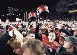  ?? Jeff Dean / Associated Press ?? Cincinnati players and fans celebrate after winning the AAC championsh­ip game against Houston on Saturday. The Bearcats became the first team outside the Power Five to reach the College Football Playoff.