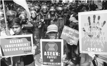  ??  ?? Demonstrat­ors display placards against US, Japan, China and the Associatio­n of Southeast Asian Nations (Asean) during a rally ahead of the Asean summit in Manila, Philippine­s. — Reuters photo