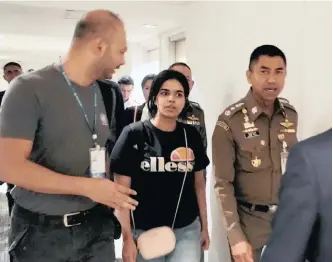  ??  ?? A PHOTO provided by the Thai Immigratio­n Bureau shows Rahaf Mohammed Alqunun, centre, being escorted by Thai immigratio­n chief Major-general Surachate Hakparn, right, and UN officials at Suvarnabhu­mi Airport in Bangkok, on Monday.