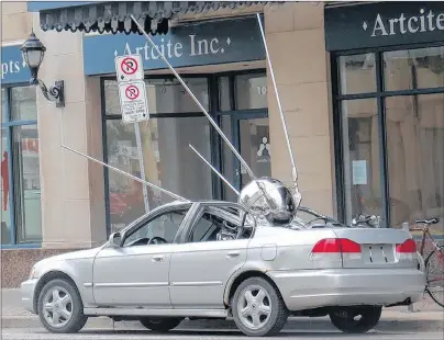  ?? SUBMITTED PHOTO ?? Hamilton artist Brandon Vickerd has created “Sputnik Returned 2” a replica of Sputnik, the first man made satellite to orbit the earth. It’s installed as if it has crash-landed into a parked sedan.