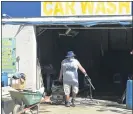  ??  ?? An employee starts the clean-up at the 69th Street Car Wash.