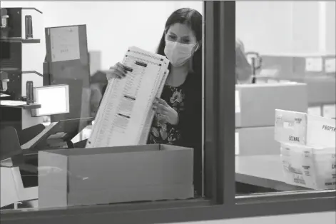  ?? ASSOCIATED PRESS ?? MARICOPA COUNTY ELECTIONS OFFICIALS count ballots, Wednesday at the Maricopa County Recorders Office in Phoenix.