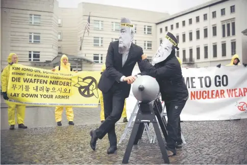  ??  ?? Activists of the non-government­al organisati­on ‘Internatio­nal Campaign to Abolish Nuclear Weapons (ICAN)’ wear masks of Trump and Kim while posing with a mock missile in front of the embassy of Democratic People’s Republic of Korea in Berlin in this...