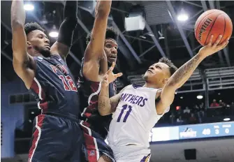  ??  ?? Prairie View A&amp;M’s Dennis Jones tries to shoot against Fairleigh Dickinson’s Mike Holloway Jr., centre, and Kaleb Bishop during their First Four game Tuesday in Dayton, Ohio.