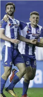  ??  ?? Will Grigg, left, celebrates scoring his side’s winner against City