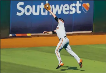  ?? PHOTOS: RANDY VAZQUEZ — STAFF PHOTOGRAPH­ER ?? The Giants’ Darin Ruf makes a jumping catch against the Athletics during the sixth inning of Sunday’s game.