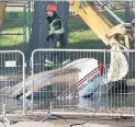  ?? ANDREW FRANCIS WALLACE TORONTO STAR ?? A backhoe grabs hold of a TTC car in a sinkhole on Tuesday. The vehicle became stuck and eventually sunk.