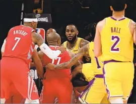  ?? Harry How Getty Images ?? LeBRON JAMES tries to pull Chris Paul away as the Houston guard fights with Rajon Rondo in a Saturday night skirmish that engulfed the Lakers and Rockets.