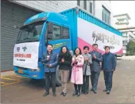  ?? PROVIDED TO CHINA DAILY ?? Representa­tives pose for photograph­s before delivering the biscuits to primary schools in Honghe prefecture, Yunnan province.
