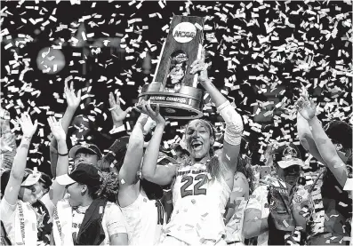  ?? Associated Press ?? n South Carolina forward A’ja Wilson holds the trophy as she and her teammates celebrate a win over Mississipp­i State in the national championsh­ip game Sunday in Dallas.