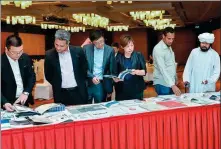  ?? XINHUA ?? Participan­ts read brochures at the China-Qatar constructi­on material and equipment fair held in Doha on Nov 21, 2018.