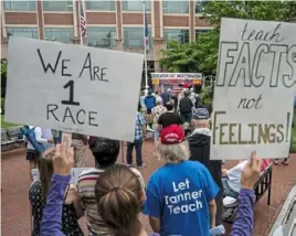  ?? AFP via Getty Images ?? People hold up signs during a rally in June at the Loudoun County Government center in Leesburg, Va., protesting against critical race theory (CRT) being taught in schools.