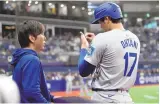  ?? ASSOCIATED PRESS ?? Los Angeles Dodgers designated hitter Shohei Ohtani, right, talks to his interprete­r Ippei Mizuhara during the fifth inning of Wednesday’s opening day game against the San Diego Padres at the Gocheok Sky Dome in Seoul, South Korea.