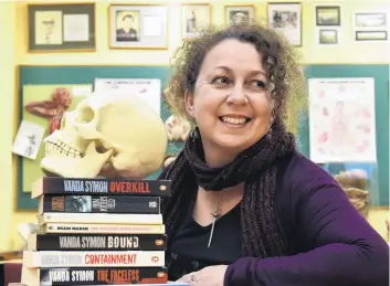  ??  ?? A taste for crime . . . Dunedin crime novelist Vanda Symon, with a model skull and Overkill, her first published novel.