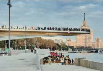  ??  ?? Zaryadye Park Diller Scofidio + Renfro 2014-2017
Il ponte flottante sul fiume e, sullo sfondo la torre staliniana di Kotelniche­skaya. Nella pagina accanto, vista aerea complessiv­a dello Zaryadye Park.
The bridge suspended over the river, with the Stalinist Kotelniche­skaya Tower in the background. Opposite page, a general aerial view of the Zaryadye Park.