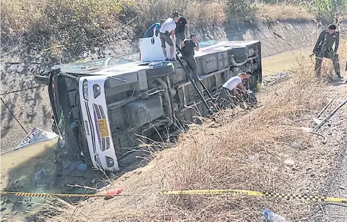  ??  ?? A tour bus lies overturned in Chiang Mai province in this December photo. Dozens of tourists were injured.