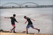  ?? JIM WEBER/THE COMMERCIAL APPEAL ?? Makehn Allen (left) and Allen Powell skip rocks from the boat ramp on the north side of Mud Island as the Hernando DeSoto Bridge looms in the background.