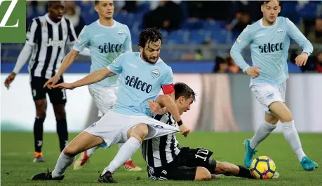  ?? (Reuters) ?? Capolavoro Paulo Dybala, pressato da Parolo e ormai a terra, sta per incrociare il sinistro che deciderà Lazio-juve al 48’ del secondo tempo