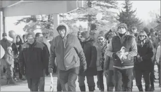  ?? Herald photo Tim Kalinowski ?? Pastor Ken Kissick (second from left) co-founder of Streets Alive Mission, leads the walkers out for The Coldest Night of the Year fundraiser at the Exhibition grounds Saturday afternoon.