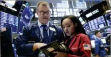  ?? RICHARD DREW — THE ASSOCIATED PRESS ?? Traders William Lawrence and Lauren Simmons work on the floor of the New York Stock Exchange, Wednesday.