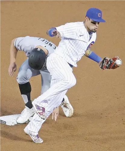  ?? JONATHAN DANIEL/GETTY IMAGES ?? The White Sox’ Adam Engel steals second base as the Cubs’ Javy Baez tries to catch his balance Friday night.