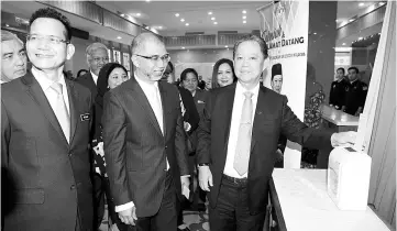  ??  ?? Tourism, Arts and Culture Minister Datuk Mohamaddin Ketapi (right), clocking in at his ministry's office in Putrajaya. Also present is his deputy Muhammad Bakhtiar Wan Chik (center). - Bernama photo