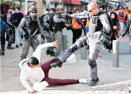  ??  ?? Israeli security forces scuffle with Palestinia­n protesters just outside Jerusalem’s Old City on Friday. (AFP)