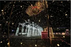  ?? (AP/Aaron Favila) ?? A car passes by Christmas displays Dec. 13 at a drive-through Christmas installati­on outside a mall in Pasay, Philippine­s.