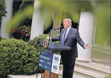  ?? Andrew Harnik Associated Press ?? PRESIDENT TRUMP appears with a premade sign at a hastily called news conference after he stormed out of the White House meeting, saying bipartisan cooperatio­n was impossible “under these circumstan­ces.”