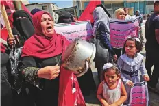  ?? AFP ?? A Palestinia­n woman beats a cooking pot during a protest against a US decision to cut funding to UNRWA, outside an aid distributi­on centre in Khan Yunis, Gaza Strip.