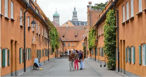  ?? Fotos: Bastian Sünkel, Felicitas Macketanz, Fred Schöllhorn und Ulrich Wagner ?? Beeindruck­t zeigen sich viele Touristen von der Fuggerei. Ein Tourist aus New York City schreibt bei Tripadviso­r, dass es „einer der interessan­teren Orte war, die ich in der Welt besucht habe.“