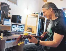  ?? FOTO: PETER KNEFFEL/DPA ?? Musikunter­richt online: Gitarrenle­hrer Johannes Deißenböck gibt von seinem Arbeitszim­mer aus einer Schülerin Unterricht.