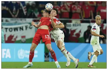  ?? (AP/Francisco Seco) ?? Walker Zimmerman of the United States and Kieffer Moore (front) of Wales battle to head the ball during Monday’s World Cup soccer match at Doha, Qatar. The teams battled to a 1-1 draw.