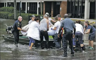  ?? AP/JOHN RAOUX ?? A patient is evacuated by boat from the St. Vincent’s Medical Center in Jacksonvil­le, Fla., after floodwater from Hurricane Irma went into the first floor of the hospital Monday.