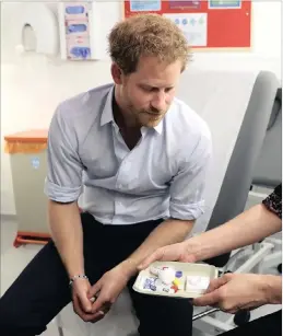  ?? PICTURE: AP ?? Britain’s Prince Harry is shown the negative result of his HIV test, during a visit to highlight the fight against HIV and Aids, at the Burrell Street Sexual Health Centre in Southwark, London on Thursday.