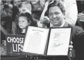  ?? JOHN RAOUX AP ?? Florida Gov. Ron DeSantis holds up the 15-week abortion-ban law after signing it on April 14 in Kissimmee.