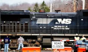  ?? Pittsburgh Post-Gazette ?? Cleanup work stops as a Norfolk Southern train passes by, six days after the train derailment in East Palestine, Ohio, on Feb. 9.