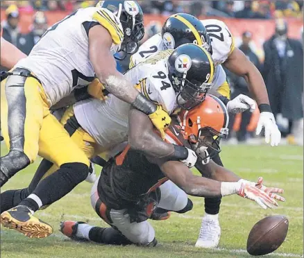  ?? Phil Masturzo
Akron Beacon Journal ?? IT’S AN ORANGE CRUSHING as Pittsburgh’s Mike Mitchell, left, Will Allen and Lawrence Timmons (94) converge on Cleveland’s Darius Jennings, who does well to recover his own fumble. The Steelers won 28-12 and, with Buffalo’s help, clinched a playoff berth.