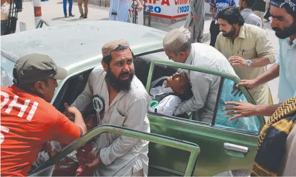  ?? Picture: AFP ?? Pakistani men transport injured blast victims at a hospital after a suicide attack near a polling station in Quetta.