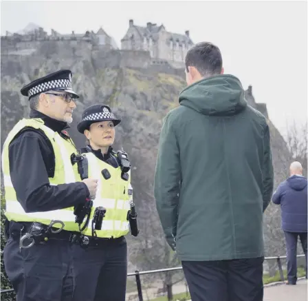  ??  ?? Police officers Bob Mason and Heather Clark speak to the public in a bid to gain more informatio­n about a package which had ‘the potential to cause injury’ when it was found in Princes Street Gardens in January