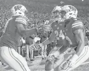  ?? Morry Gash / Associated Press ?? Wisconsin’s Bradrick Shaw, left, celebrates his touchdown run with Adam Krumholz, center, and Kendric Pryor during the Badgers’ win over Iowa.