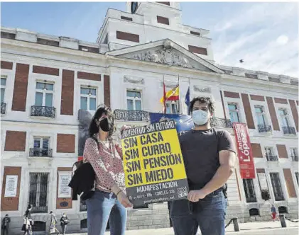  ?? ANA MÁRQUEZ ?? 33
Juan y Silvia posan en la Puerta del Sol con uno de los carteles anunciador­es de la concentrac­ión del 2011.