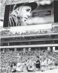  ??  ?? Miami Dolphins fans stand for a minute of silence for Marlins pitcher Jose Fernandez, who was killed early Sunday in a boating accident.