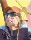  ??  ?? ABOVE: Peg Billson of Albuquerqu­e, pilot of the “Play Me” balloon, wears a heart sticker on her cheek as she takes off on Sunday at the Friends and Lovers rally.